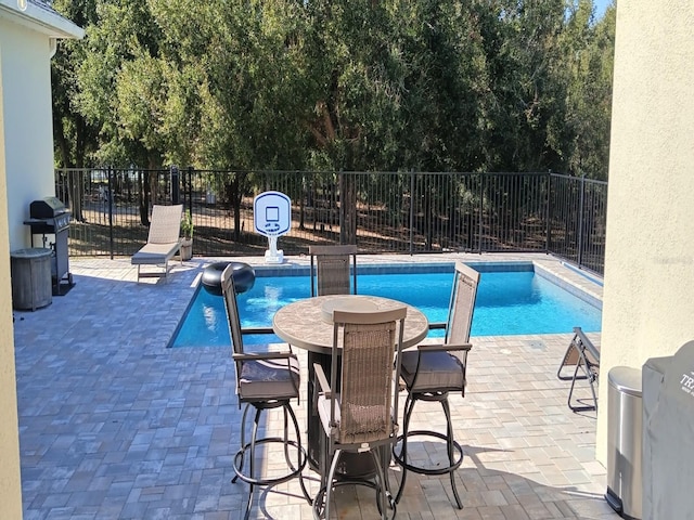 view of swimming pool featuring a patio area and a grill