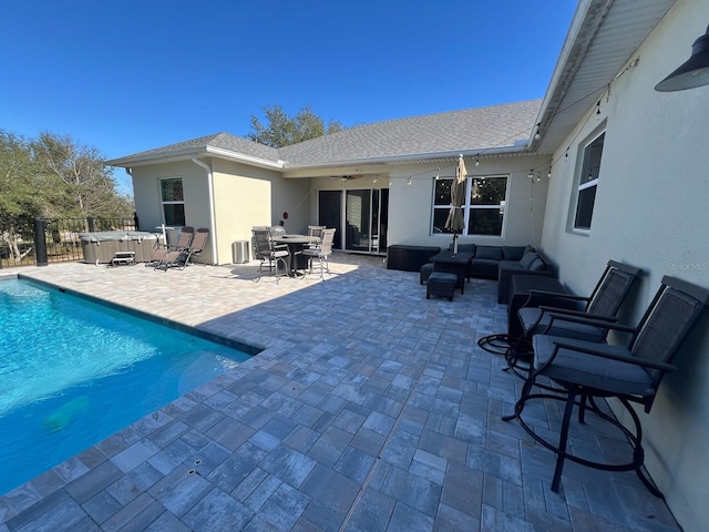 exterior space with an outdoor living space, a hot tub, ceiling fan, and a patio area