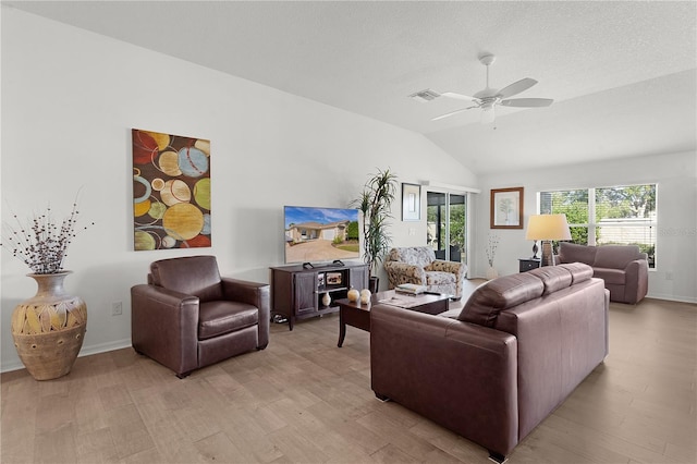 living room featuring ceiling fan, vaulted ceiling, a textured ceiling, and light hardwood / wood-style flooring