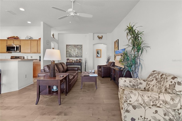 living room featuring a textured ceiling, light hardwood / wood-style floors, and ceiling fan