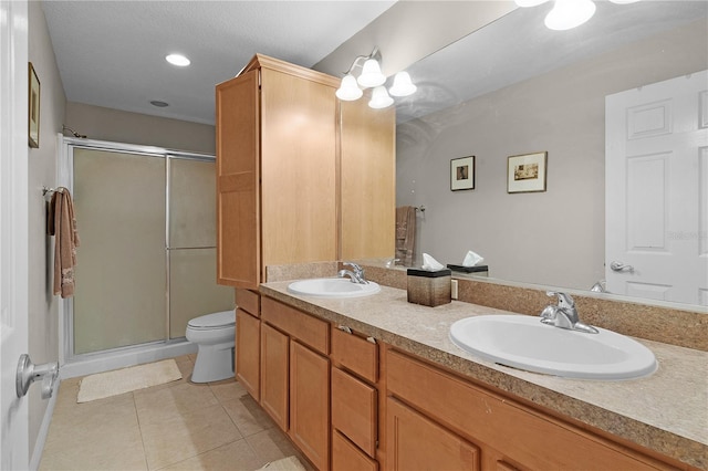 bathroom with tile patterned flooring, vanity, toilet, and walk in shower