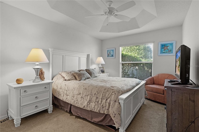 bedroom with a tray ceiling, ceiling fan, and light colored carpet