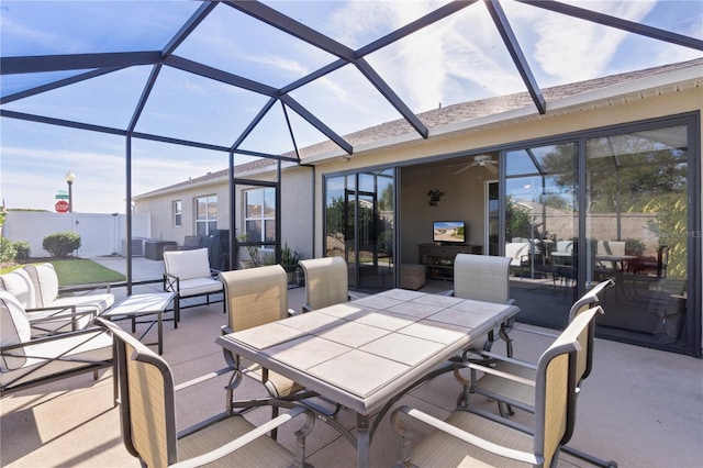 view of patio with ceiling fan and a lanai