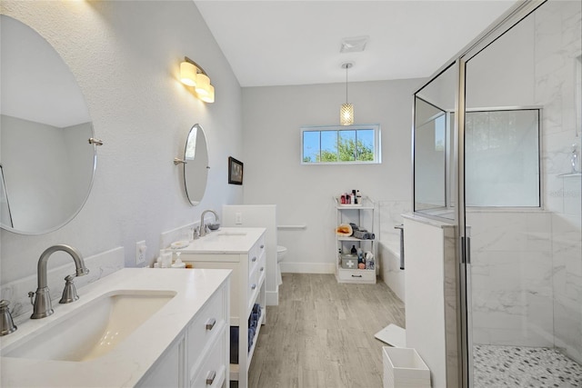 full bathroom with hardwood / wood-style flooring, vanity, separate shower and tub, and toilet