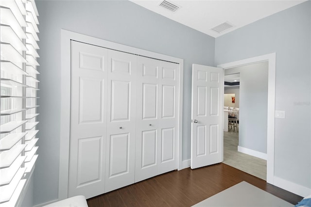 unfurnished bedroom featuring dark hardwood / wood-style floors and a closet