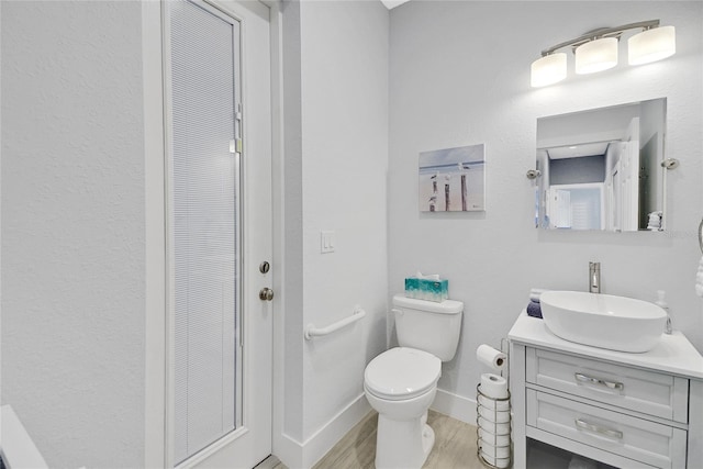 bathroom featuring hardwood / wood-style flooring, vanity, and toilet