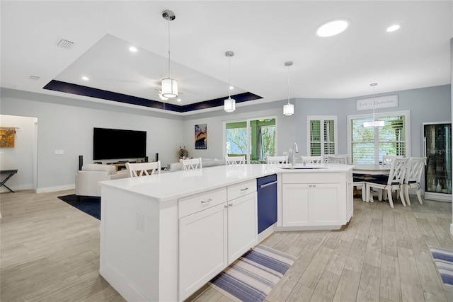 kitchen with a raised ceiling, sink, white cabinets, and light hardwood / wood-style flooring