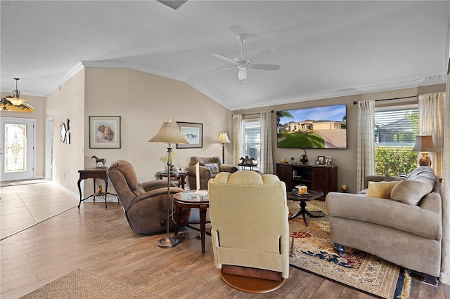 living room featuring ceiling fan, a healthy amount of sunlight, light hardwood / wood-style floors, lofted ceiling, and ornamental molding