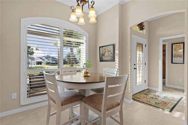 dining area with light tile patterned floors, ornamental molding, and a notable chandelier