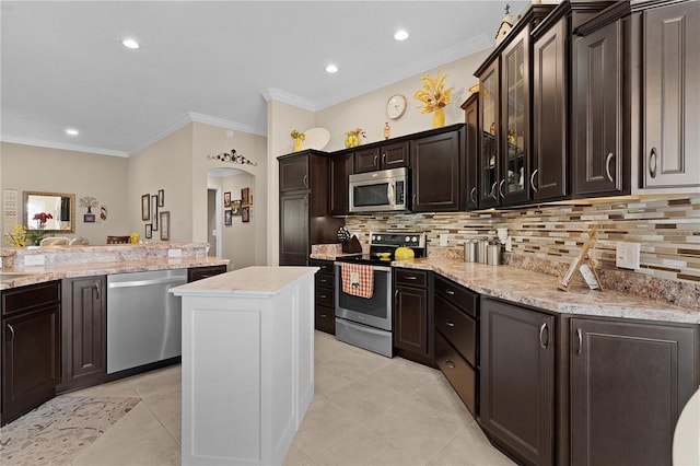 kitchen featuring crown molding, dark brown cabinets, a kitchen island, and stainless steel appliances