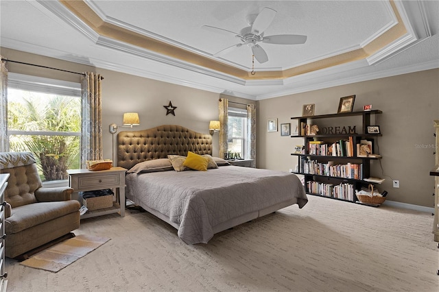 carpeted bedroom featuring ceiling fan, a raised ceiling, and crown molding