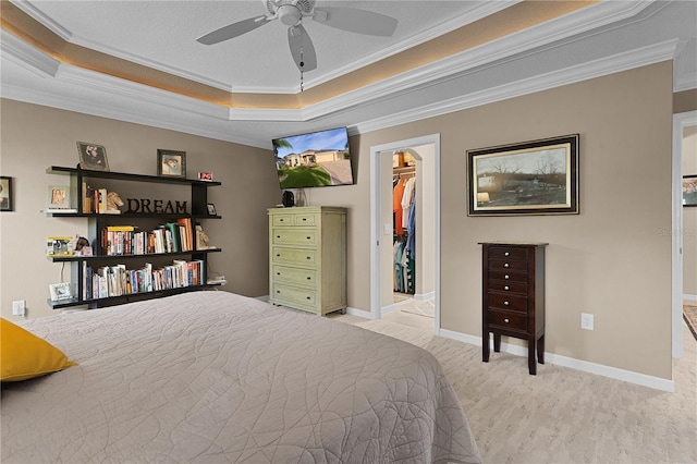 bedroom featuring ceiling fan, a walk in closet, ornamental molding, and a closet