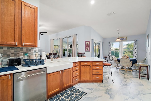 kitchen featuring kitchen peninsula, backsplash, stainless steel dishwasher, sink, and hanging light fixtures