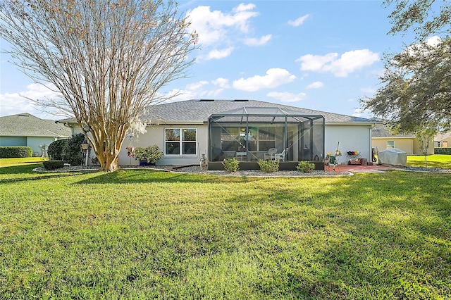 rear view of property with glass enclosure and a lawn