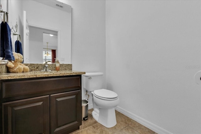 bathroom featuring tile patterned flooring, vanity, and toilet