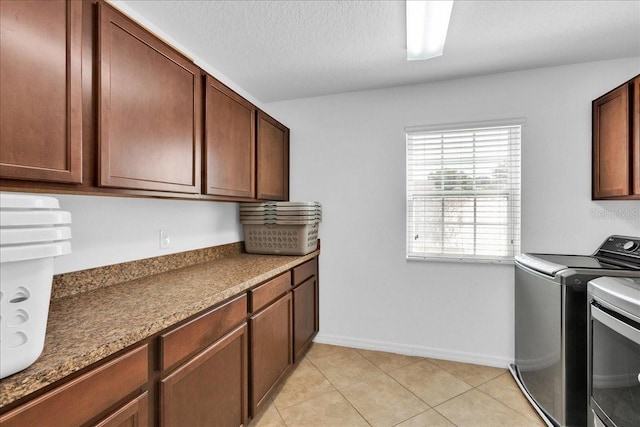 laundry area with light tile patterned floors, cabinets, and independent washer and dryer