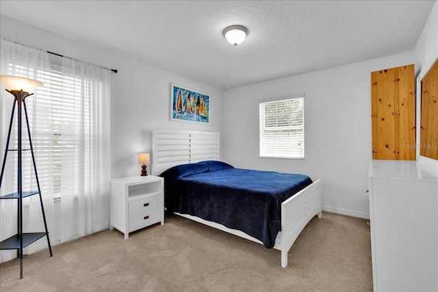 carpeted bedroom featuring multiple windows and a textured ceiling