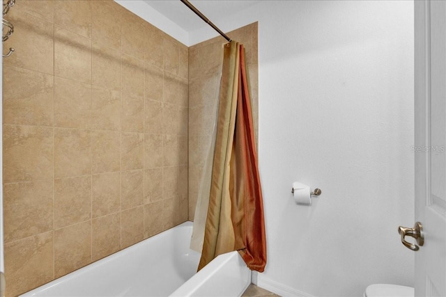 bathroom featuring toilet and shower / bath combo with shower curtain