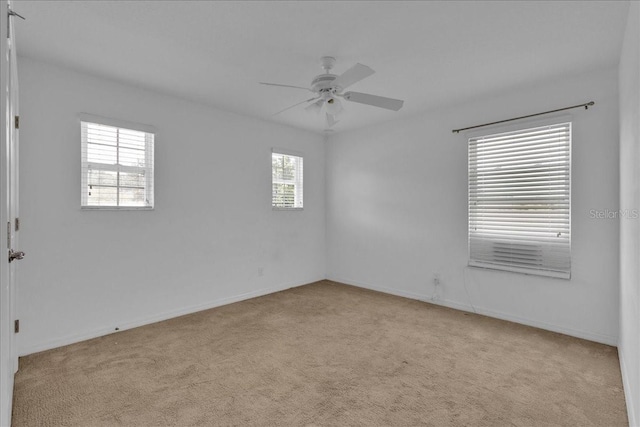 empty room featuring ceiling fan and light carpet