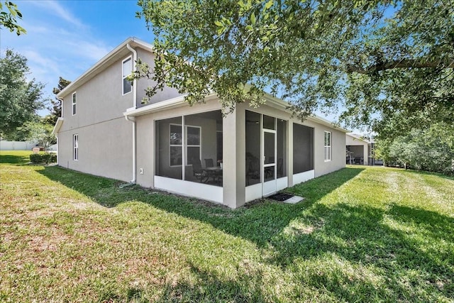 rear view of property with a sunroom and a yard