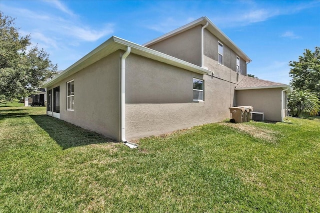 view of side of home featuring a lawn and cooling unit