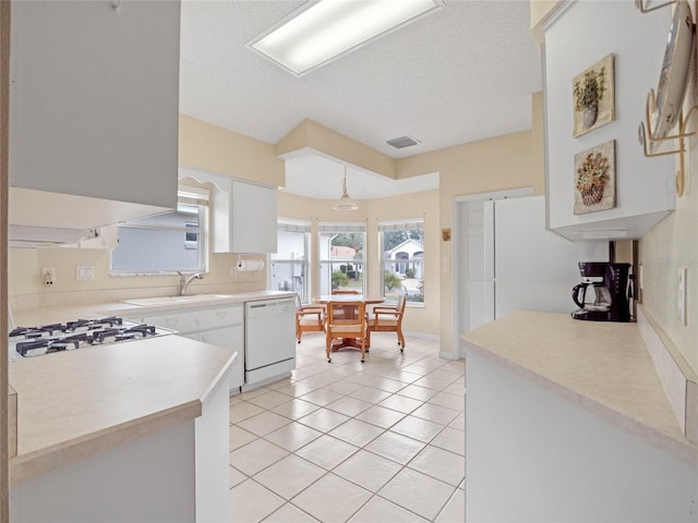 kitchen with sink, a textured ceiling, gas cooktop, white dishwasher, and white cabinets