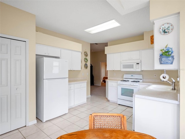 kitchen featuring white cabinetry, white appliances, light tile patterned flooring, and sink