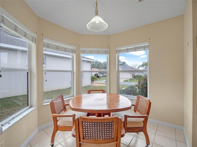 tiled dining room featuring a textured ceiling