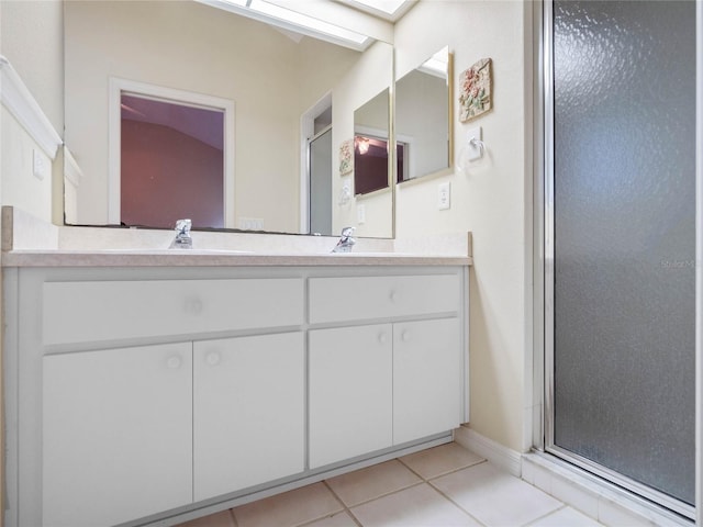 bathroom with tile patterned floors, a shower with door, and vanity