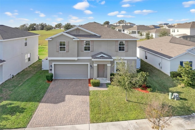 view of property featuring a front yard and a garage