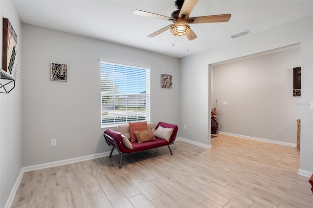 living area featuring ceiling fan and light hardwood / wood-style flooring