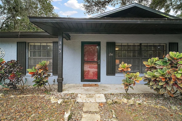 view of exterior entry featuring covered porch