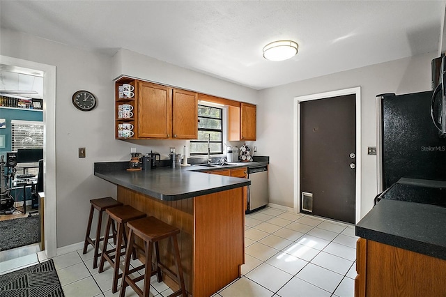 kitchen featuring a breakfast bar, dishwasher, kitchen peninsula, and light tile patterned floors