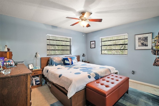 carpeted bedroom with multiple windows, a textured ceiling, and ceiling fan