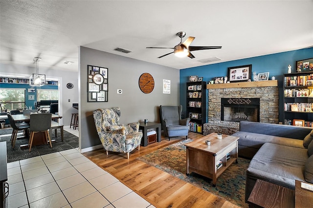 living room featuring hardwood / wood-style floors, ceiling fan, and a fireplace