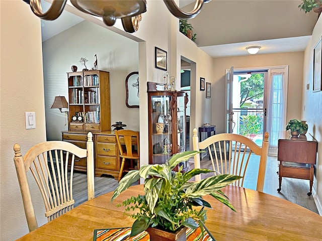 dining space with hardwood / wood-style floors and lofted ceiling