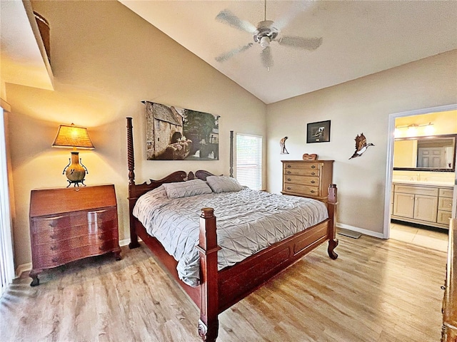 bedroom featuring ceiling fan, light hardwood / wood-style floors, connected bathroom, and vaulted ceiling