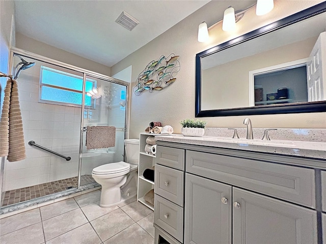 bathroom featuring tile patterned floors, vanity, toilet, and an enclosed shower