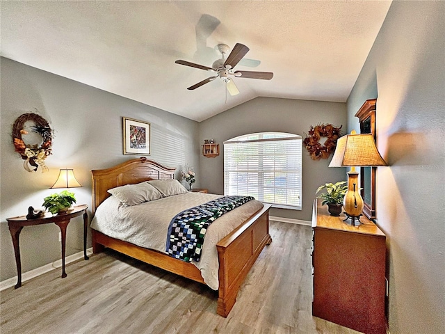 bedroom featuring ceiling fan, light hardwood / wood-style flooring, and vaulted ceiling