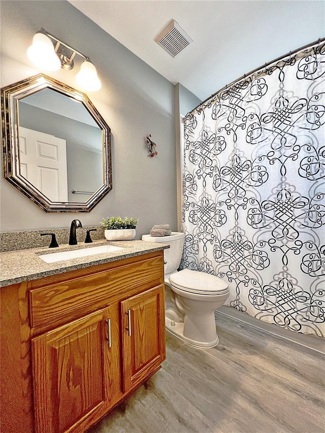 bathroom featuring hardwood / wood-style floors, vanity, and toilet