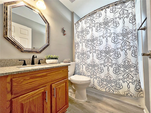 bathroom with curtained shower, vanity, wood-type flooring, and toilet