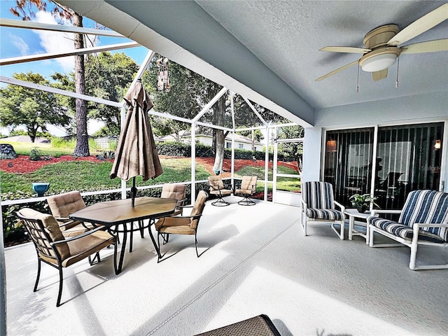 view of patio featuring glass enclosure and ceiling fan