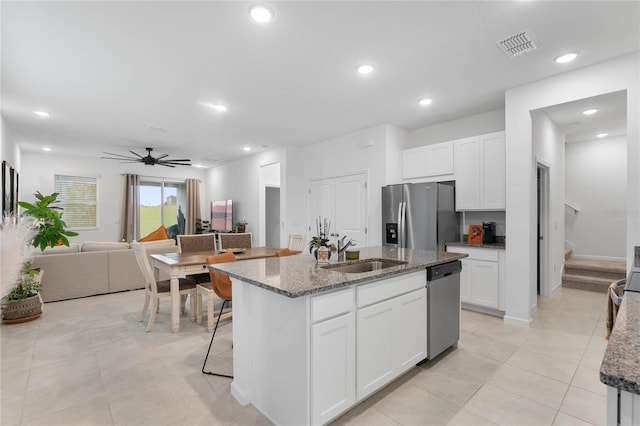 kitchen with white cabinetry, an island with sink, stainless steel appliances, and sink