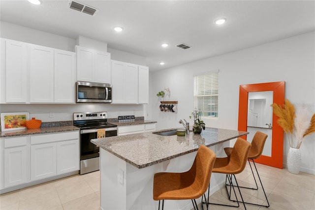 kitchen featuring white cabinetry, an island with sink, appliances with stainless steel finishes, and sink