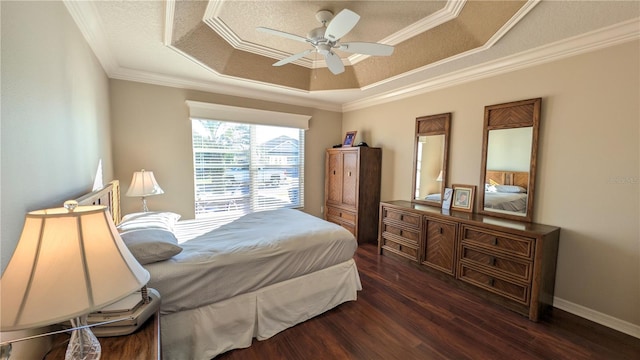 bedroom with dark hardwood / wood-style flooring, a tray ceiling, ceiling fan, and crown molding