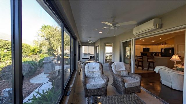 sunroom with a wall mounted AC and ceiling fan