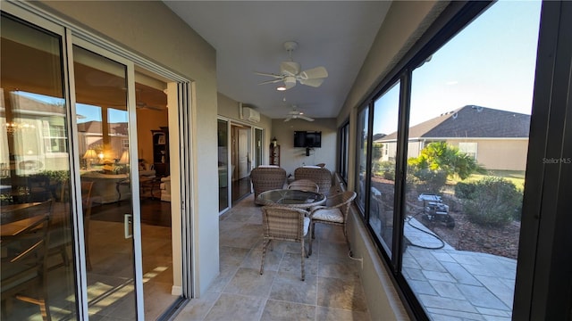 sunroom featuring an AC wall unit and ceiling fan