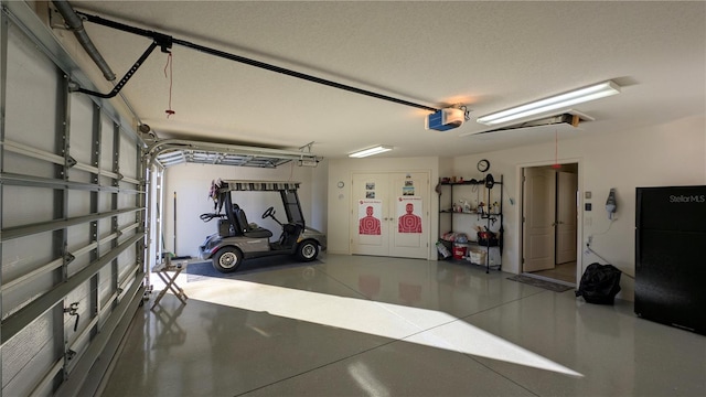 garage with black fridge, a garage door opener, and french doors