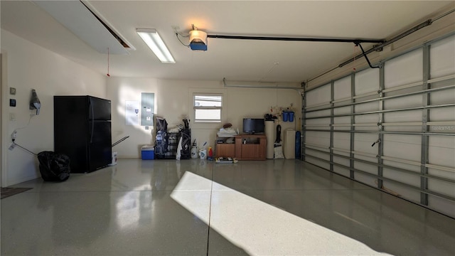 garage with a garage door opener, electric panel, and black fridge