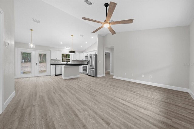 unfurnished living room featuring ceiling fan, light hardwood / wood-style floors, lofted ceiling, and french doors